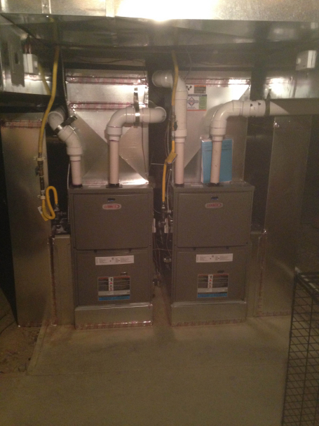 two lennox furnace side by side in a basement