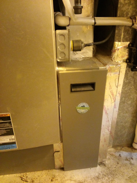 a close up of a lennox furnace unit installed in a home with a filter attachment