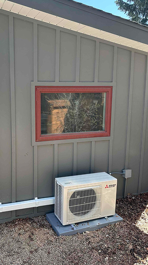 mitsubishi condenser in front of a grey sided home