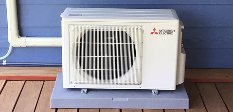 an outdoor condenser mini split unit in front of a blue wall