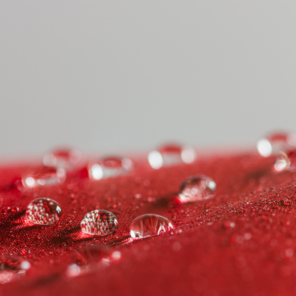 a red raincoat with water beads on it