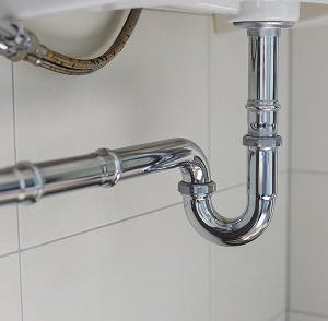 curved metal pipe underneath a sink